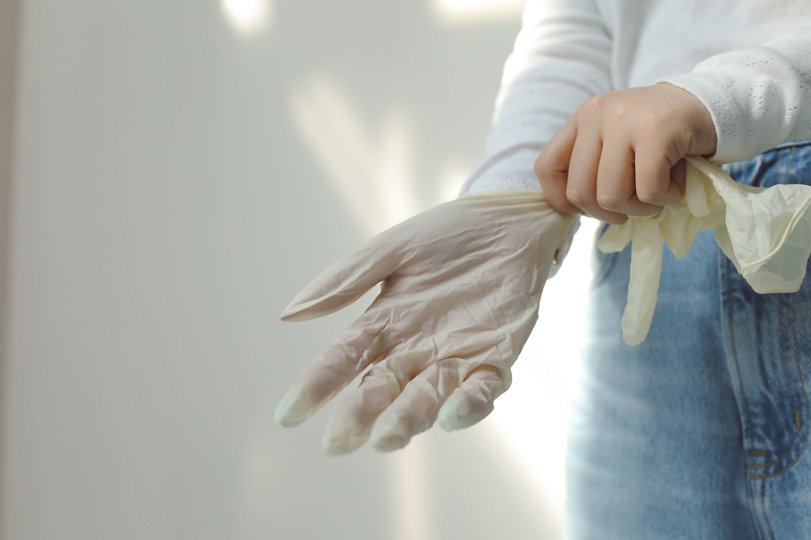 Hands putting on a disposable glove