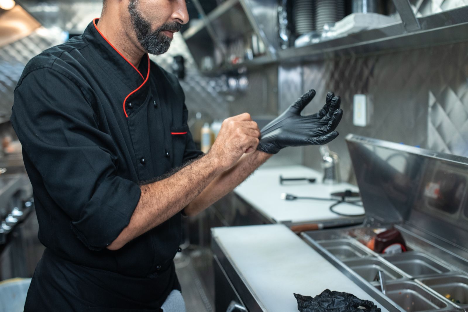 Food service worker putting on a glove